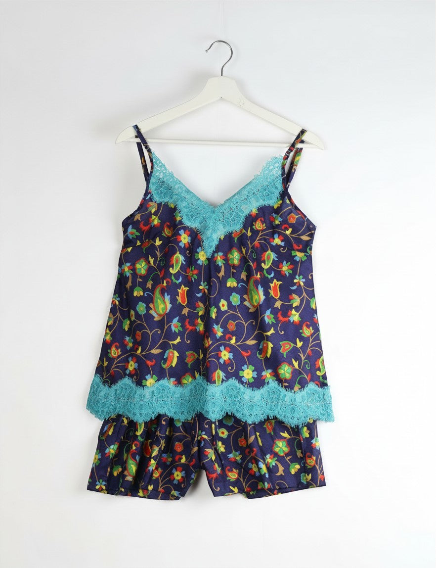 Invogue Again sustainable floral print camisole and shorts PJ set with turquoise eyelash lace trim on a white hanger.