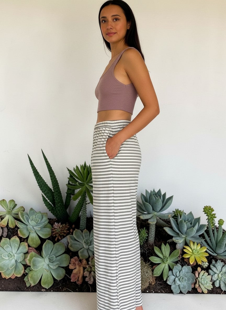 Modella indossa pantaloni Invogue Again GIOTTA a righe bianche e grigie in cotone con vita elastica e tasche laterali