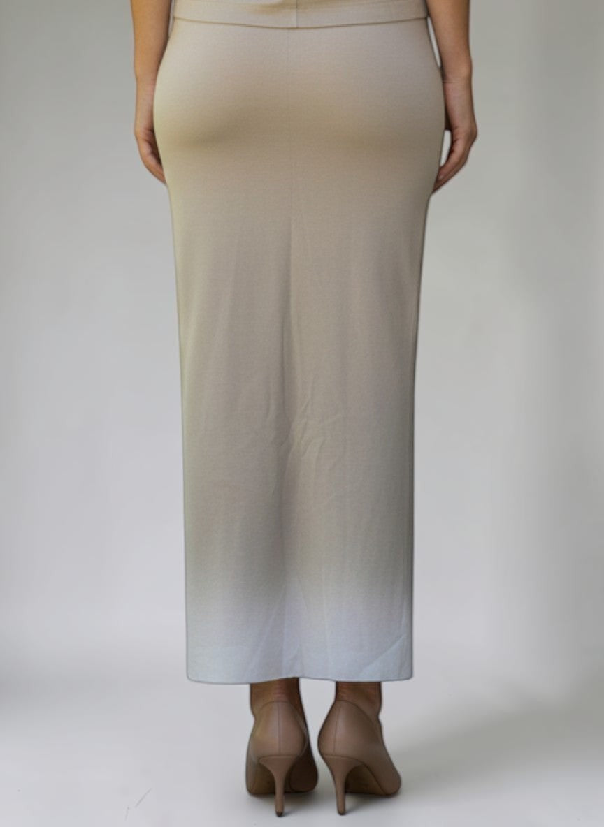 Modella di spalle indossa gonna lunga beige Invogue Again abbinata a top smanicato coordinato su sfondo neutro