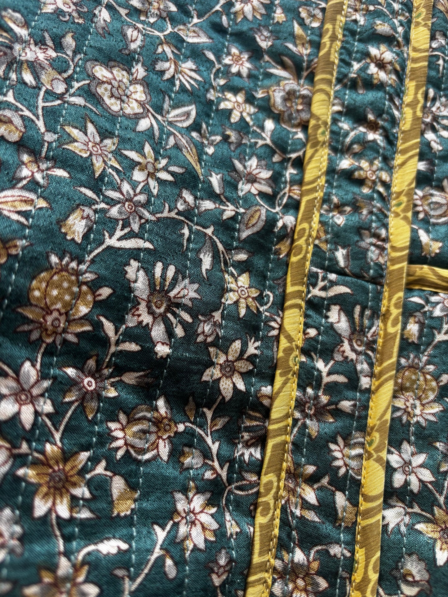 Invogue Again quilted work tote bag featuring a dark green floral sari fabric with gold trim and chevron stitching.