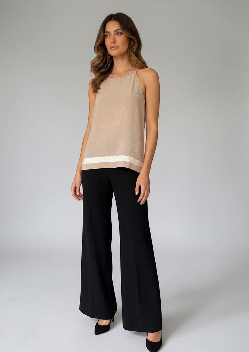 Modella indossa il top beige Invogue Again con scollo rotondo e dettaglio a contrasto sull'orlo, abbinato a pantaloni