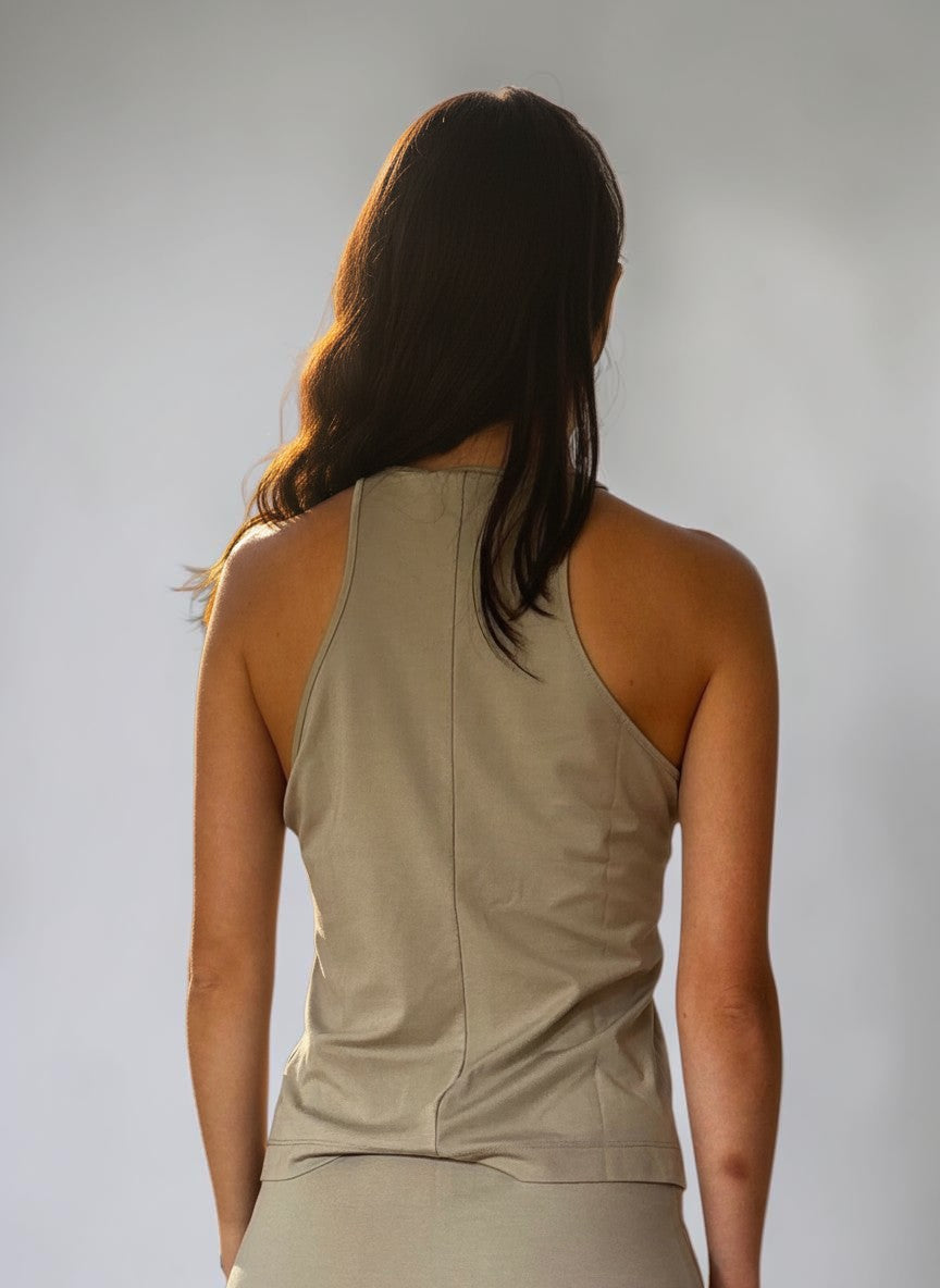 Top in jersey beige Invogue Again con scollo all'americana visto di schiena in un contesto naturale al tramonto